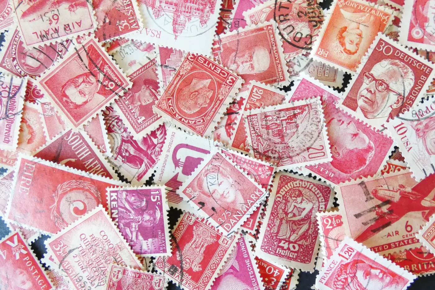 A collection of red-coloured postage stamps from around the world.